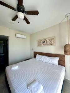 a bedroom with a bed with a ceiling fan at Apartment OceanView near Bacalar in Mahahual