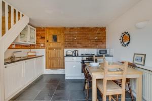 a kitchen with a table and chairs and a sink at Jasmine Cottage in Woodbridge