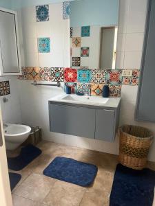 Un baño con lavabo, espejo e inodoro. en Una Civetta al Mare, en Monopoli