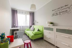 a living room with a green couch and a table at Apartamenty Startowa Gdańsk in Gdańsk