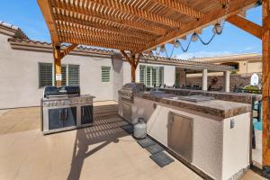 an outdoor kitchen with a grill and an outdoor bar at Havasu Duke Pool Spa Basketball Central in Lake Havasu City