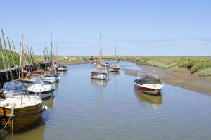 un groupe de bateaux est amarré dans une rivière dans l'établissement Dottys Cottage, à Blakeney 4 autres photos