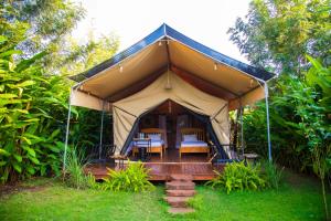 a tent with chairs and tables in a yard at Kibo View Farm Lodge in Shiri