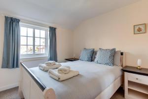 a bedroom with a large bed with towels on it at 30 Victoria Street in Southwold