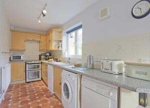 a kitchen with a washer and dryer at Hope Cove in Thorpeness +10 photos