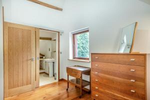 a bathroom with a wooden dresser and a mirror at Pelican Barn in East Carleton +30 photos
