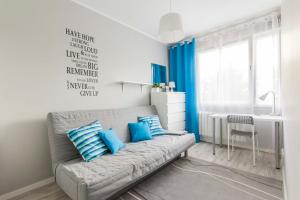 sala de estar con sofá y almohadas azules en Apartamenty Startowa Gdańsk en Gdansk