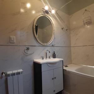 a bathroom with a sink and a mirror and a tub at ARWEN Suites 1 in Trevelin +20 photos