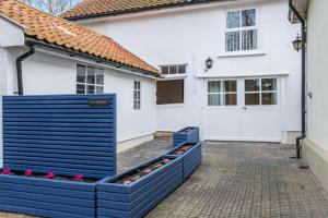 a house with a blue fence in front of it at The Coach House at Hill House in Eye +4 photos