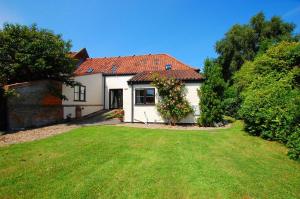 a white house with a large yard in front of it at Leath Barn Cottage in Somerton