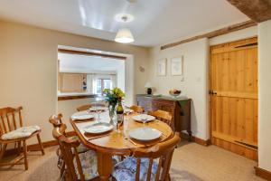 a dining room with a wooden table and chairs at Leath Barn Cottage in Somerton