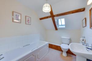 a bathroom with a tub and a sink and a toilet at Leath Barn Cottage in Somerton +10 photos
