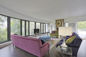 a living room with purple furniture and large windows at Stone Farm in Lavenham