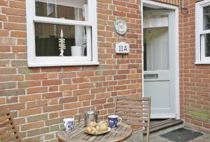 a table with a plate of food on it next to a brick building at Stones Throw in Southwold