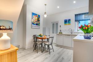 a kitchen and dining room with a table and chairs at Seaglass Cottage in Hythe +6 photos