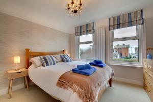a bedroom with a bed with blue towels on it at Seaglass Cottage in Hythe