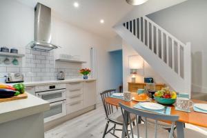 a kitchen and dining room with a table and chairs at Seaglass Cottage in Hythe