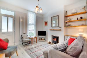a living room with a couch and a fireplace at Seaglass Cottage in Hythe