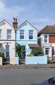 a blue house on the corner of a street at Seaglass Cottage in Hythe