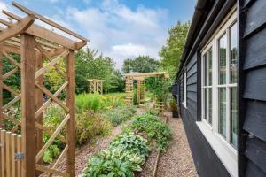 a garden with a wooden trellis next to a house at Woodland Lodge in Wilby