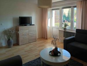 Una sala de estar con un sofá, un televisor y una mesa. en SIELSKO - ANIELSKO Apartamenty 96m2, Kielce, Ogród, Grill, Bezpłatny Parking, en Kielce