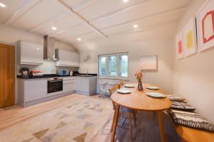 a kitchen and dining room with a table and chairs at Rose Cottage in Middleton