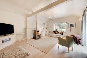 a living room with a television and a couch at Rose Cottage in Middleton