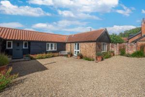 a house with a gravel driveway in front of it at Rose Cottage in Middleton