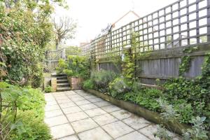 een tuin met een hek en een patio bij Box Cottage in Snape