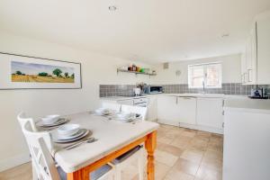 een keuken met een tafel met borden erop bij Box Cottage in Snape