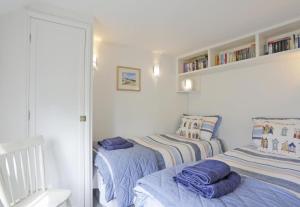 een slaapkamer met twee bedden en een spiegel bij Box Cottage in Snape