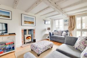 een woonkamer met een bank en een open haard bij Box Cottage in Snape