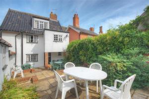 a patio with a table and chairs and a house at 4 Bed in Saxmundham oc-oth in Dunwich