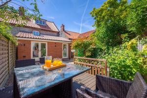 eine Terrasse mit Tisch und Stühlen auf einem Deck in der Unterkunft Fishermen's Cottage in Sheringham