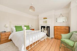 a bedroom with a white bed and a chair at 23 Stradbroke Road in Southwold