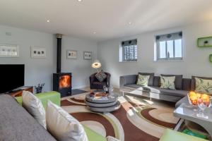 a living room with a couch and a fireplace at East Barn Cottage in Aldringham