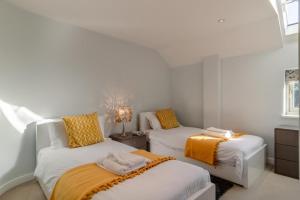 a white room with two beds and a window at East Barn Cottage in Aldringham