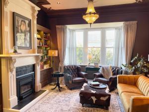 a living room with a couch and chairs and a fireplace at Central Blenheim Villa in Blenheim