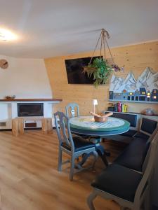 a living room with a table and chairs and a tv at Il Rifugio dell'Artista in Folgarida