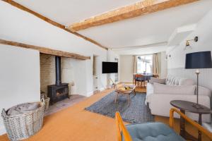a living room with a couch and a fireplace at London Cottage in Halesworth