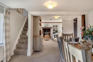 a living room with a staircase and a dining room at Alde Cottage in Friston