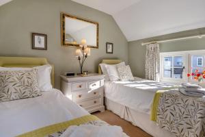 a bedroom with two beds and a mirror at Alde Cottage in Friston