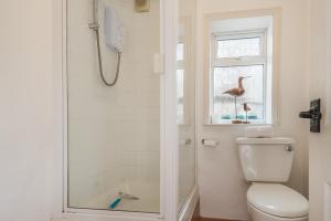 une salle de bain avec douche et toilettes et une fenêtre dans l'établissement Fishermans House, à Sheringham