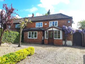ein Backsteinhaus mit einem Tor und einer Einfahrt in der Unterkunft Haven Cottage in South Walsham