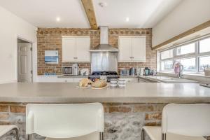 une cuisine avec un comptoir et des chaises. dans l'établissement Fishermans House, à Sheringham 20 autres photos