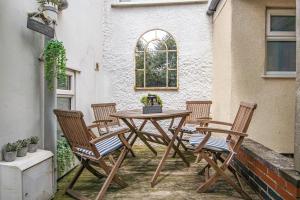une table et quatre chaises sur la terrasse dans l'établissement Fishermans House, à Sheringham