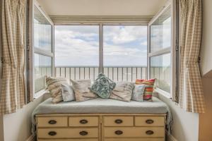 - un siège de fenêtre avec des oreillers en face d'une fenêtre dans l'établissement Fishermans House, à Sheringham
