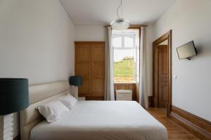 Un dormitorio con una cama blanca y una ventana. en Casa de Cambres - by RowdHouses, en Lamego 31 fotos más