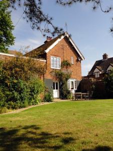 a brick house with a bench in front of it at Wing Cottage in Orford