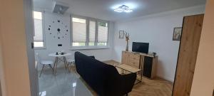 a living room with a table and a clock on the wall at Studio pod Gmachem in Chełm